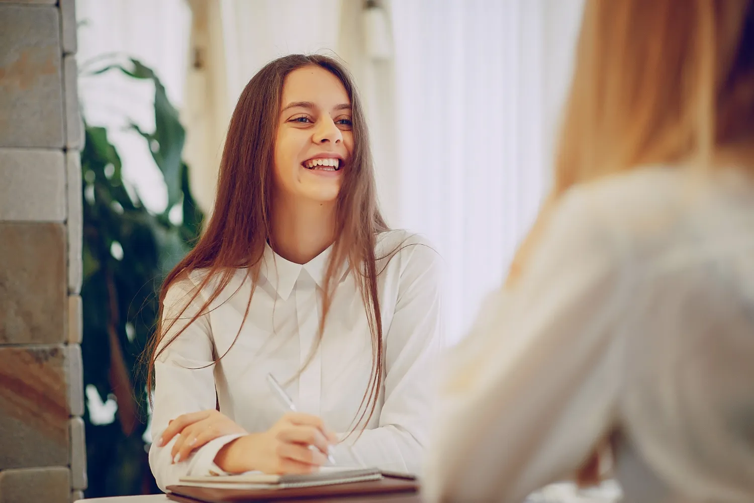 A cheerful candidate confidently engaging in a practice interview, embodying the proactive approach to preparation encouraged by JOH Partners for optimal interview performance.