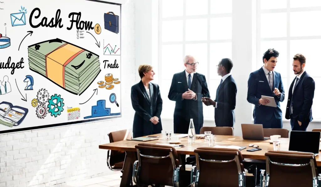 A group of professionals in a meeting room with a creative 'Cash Flow' concept mural on the wall, representing the financial expertise provided by JOH Partners.