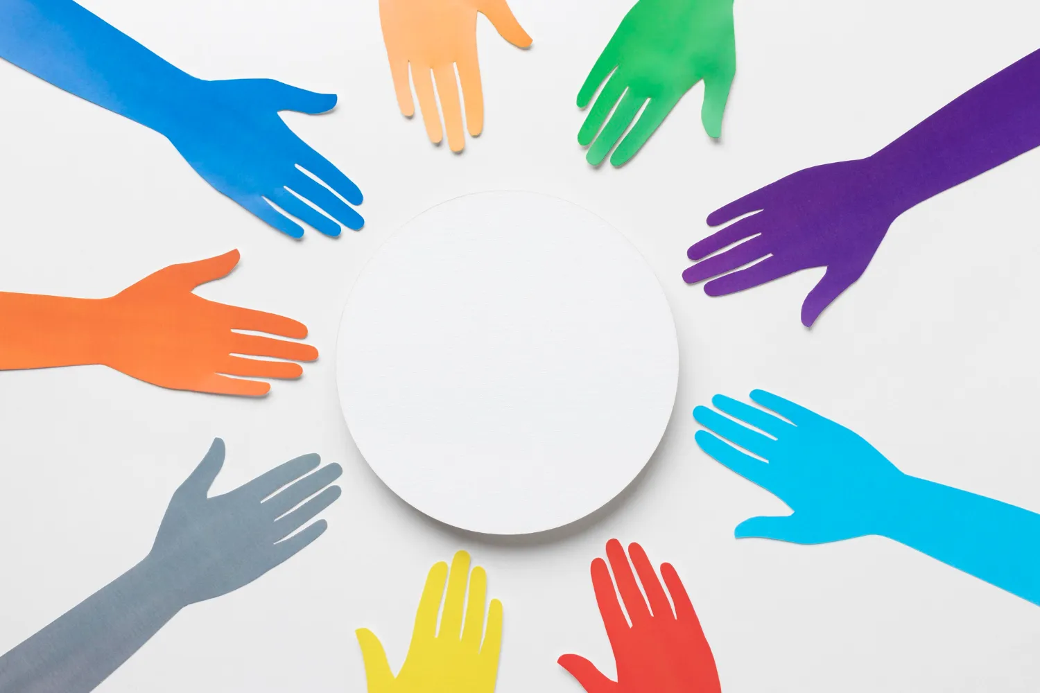 Colorful paper hands in blue, green, orange, red, yellow, and purple extend towards a white circle, representing the diverse elements of a psychological contract in the workplace, as discussed by JOH Partners.