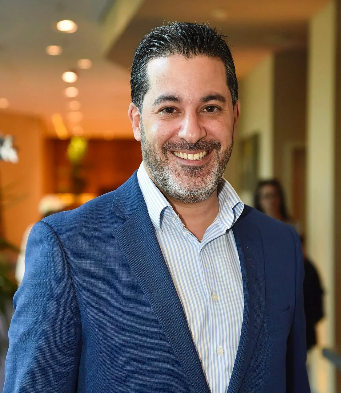 Portrait of Hussein Wehbe smiling confidently in a professional setting, representing effective leadership principles discussed in JOH Partners' podcast on managing workplace dynamics and career growth.